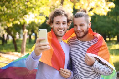 Mutlu gay çift alarak selfie gökkuşağı Lgbt bayrağı Park ile