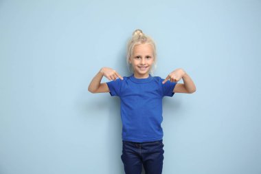 Sevimli küçük kız onun t-shirt renk arka plan üzerine işaret