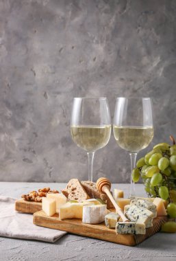 Bardak beyaz şarap aperatifler ve gri masada Olgun üzüm ile