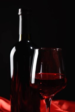 Şişe ve bardak koyu arka plan üzerinde kırmızı şarap
