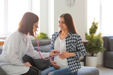 Genç doktor muayene hamile kadın Kliniği