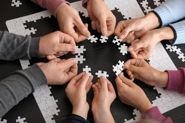 Group People Holding Pieces Puzzle Dark Table — Stock Photo, Image