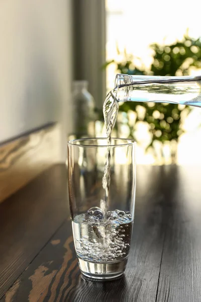 Pouring Fresh Water Bottle Glass Wooden Table — Stock Photo, Image