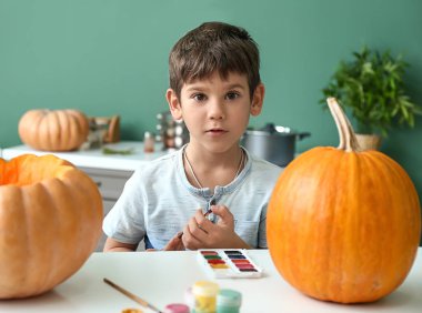Sevimli küçük çocuk Cadılar Bayramı'nda evde kabak hazırlama