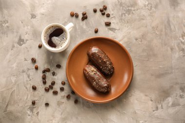 Lezzetli eklerleri ve gri masada kahve ile plaka