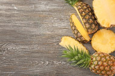 Ahşap arka plan üzerinde tüm ve kesme olgun ananas