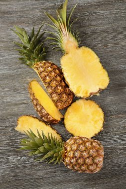 Ahşap arka plan üzerinde tüm ve kesme olgun ananas