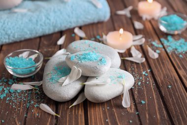 Deniz tuz ve çiçek yaprakları ahşap masa üzerinde taşlarla Spa