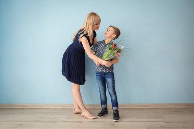 Sevimli küçük çocuk onun veren anne lale buketi kapalı