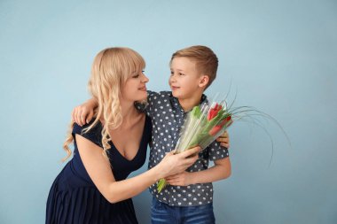 Sevimli küçük çocuk ve annesi Lale buketi gri arka plan üzerinde ile portre
