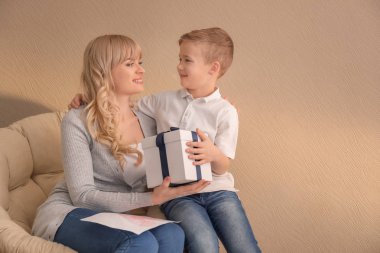 Portre sevimli küçük çocuk ve annesi ile renk arka plan üzerinde hediye kutusu