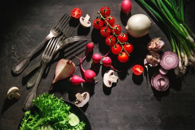 Çeşitli sebze ve çatal koyu arka plan üzerinde düz yatıyordu kompozisyonu