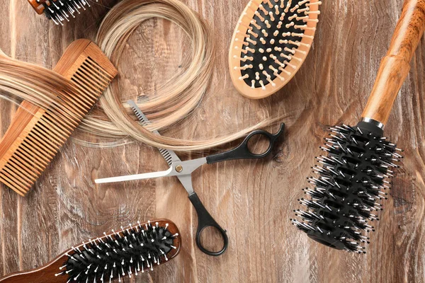 Flache Lagekomposition Mit Friseurwerkzeugen Und Blonden Haarsträhnen Auf Holzgrund — Stockfoto