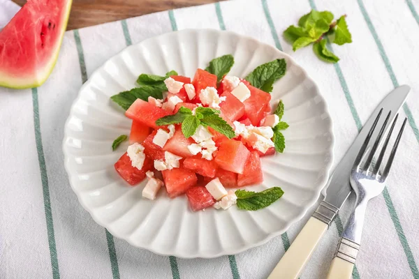 Plate with delicious watermelon salad on table