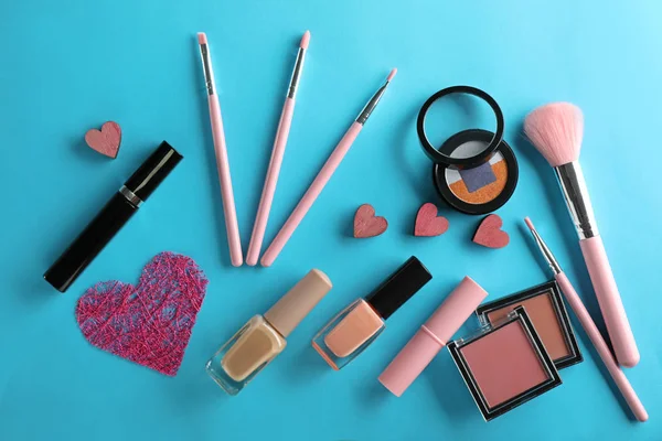Set of cosmetics with small hearts on color background