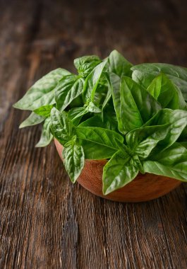 Ahşap masa üzerinde yeşil Taze Fesleğenli kase