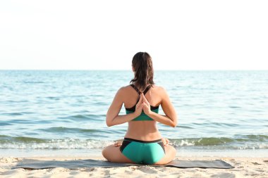 Pratik yoga deniz kıyısında kadın