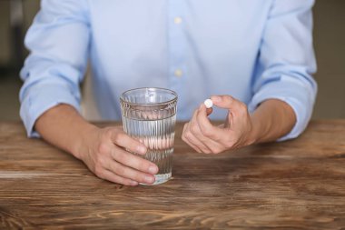 Ahşap masa, closeup hap ve su tutan adam