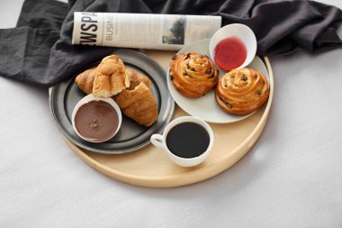 Lezzetli kahvaltı ve gazete yatakta