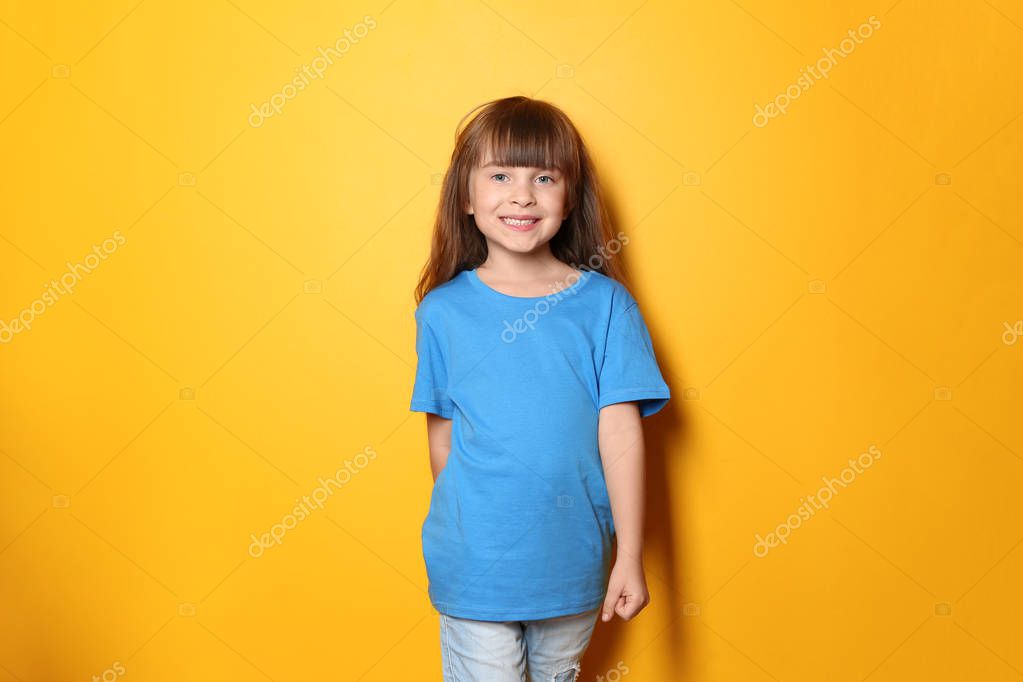 Little girl in t-shirt on color background