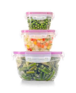 Beyaz arka planda donmuş sebzeli plastik kaplar.