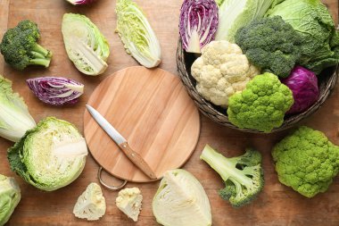 Ahşap arka plan üzerinde kesme tahtası ile lahana çeşitleri