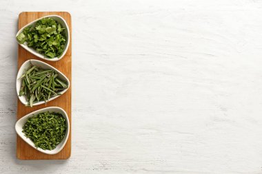 Beyaz ahşap zemin üzerinde kesme aromatik otlar ile plakalar