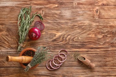 Baharatlar ve ahşap zemin üzerine kesilmiş soğan taze aromatik bitkiler