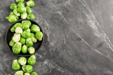 Gri arka plan, üstten görünüm üzerinde taze Brüksel lahanası ile plaka