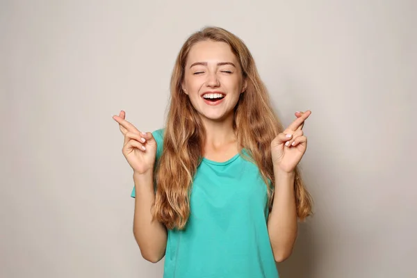 Portret Van Mooie Jonge Vrouw Met Gekruiste Vingers Lichte Achtergrond — Stockfoto