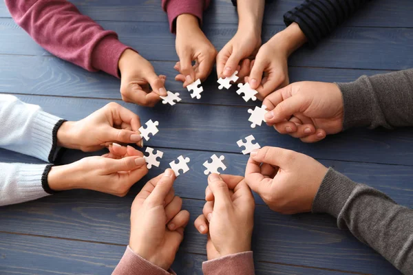 Group People Holding Pieces Puzzle Wooden Table — Stock Photo, Image