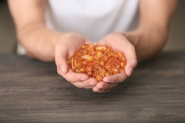 Kapsül ahşap masa, closeup üzerinde tutan adam