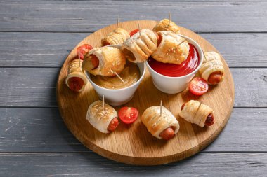 Kurulu lezzetli Sosisli rulo ve ahşap masa üzerinde soslar