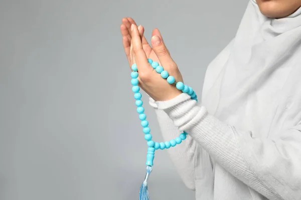 Junge Muslimische Frau Mit Rosenkranzperlen Die Auf Hellem Hintergrund Beten — Stockfoto