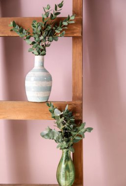 Ahşap merdiven üzerinde yeşil okaliptüs dalları ile vazo