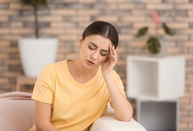 Evde baş ağrısı çeken bir kadın.