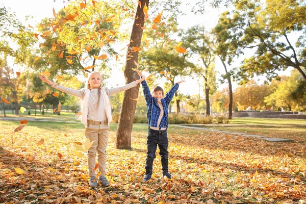 孩子们玩树叶在秋天的公园 — 图库照片