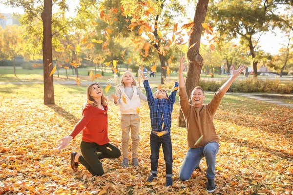 愉快的家庭玩叶子在秋天公园 — 图库照片