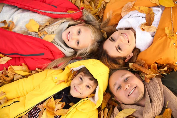 幸福的家庭躺在干燥的叶子在秋天公园 — 图库照片
