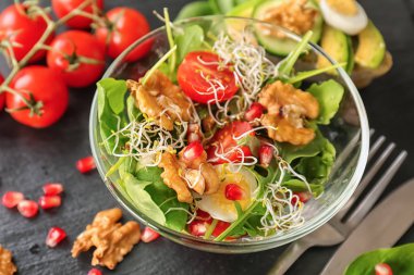 Karanlık masada cam kapta ceviz ile lezzetli taze salata