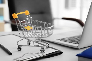 Küçük sepeti ve masa üstünde laptop. Internet alışveriş kavramı