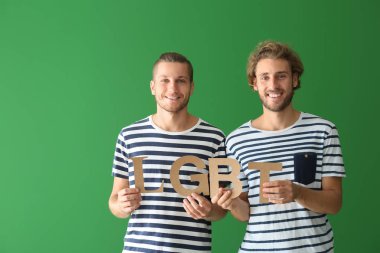 Mektupları yeşil arka plan üzerinde tutan mutlu Lgbt çift