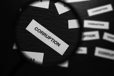Kelime CORRUPTION ile kağıt parçası üzerinde görünüm siyah arkaplan üzerindeki büyüteç cam üzerinden