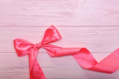 Renk ahşap arka plan üzerinde yay ile pembe kurdele kıvrılmış