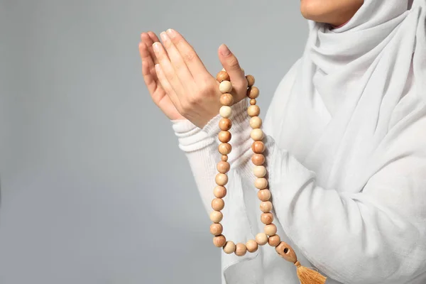 Junge Muslimische Frau Mit Rosenkranzperlen Die Auf Hellem Hintergrund Beten — Stockfoto
