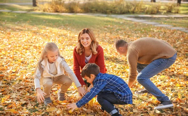 秋の公園で遊んで幸せな家族を葉します — ストック写真