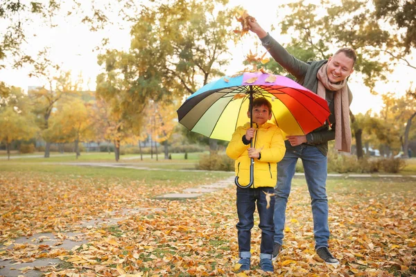 愉快的父亲和儿子与五颜六色的伞在秋天公园 — 图库照片