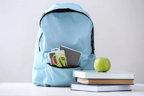 Mochila Con Útiles Escolares Sobre Fondo Claro —  Fotos de Stock