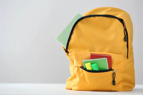 Rucksack Mit Schulmaterial Auf Hellem Hintergrund — Stockfoto