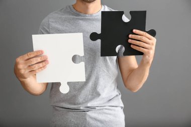 Gri arka plan, closeup jigsaw bulmaca parçaları ile genç adam